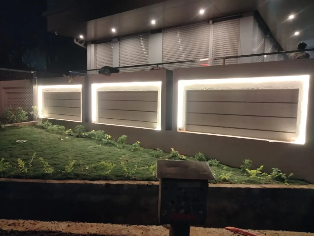 Backlit LED lighting installed along a residential compound wall at night