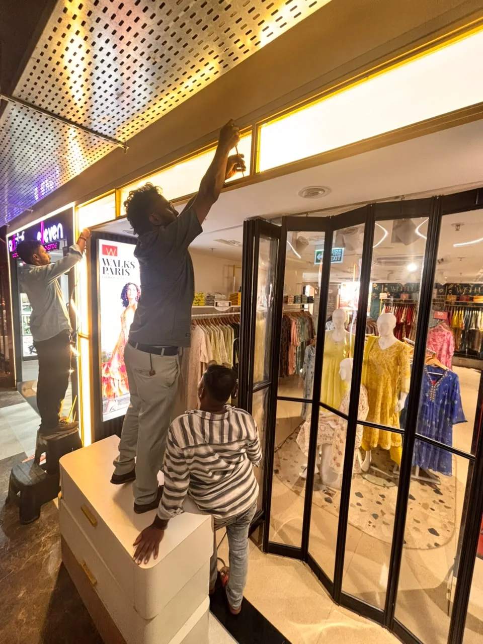 Electrical contractors installing lighting at a retail storefront